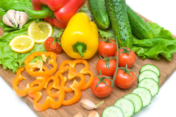 vegetables and lemon on a cutting board on a white background