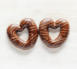 Chocolate hearts on white wooden table.