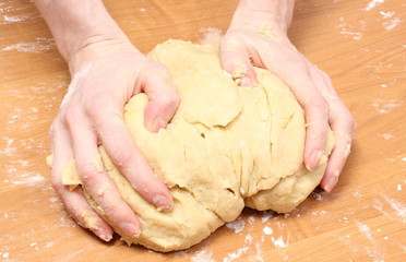 Hand of woman kneading dough for yeast cake