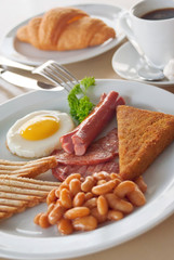 English Breakfast with sunny-side-up fried eggs, sausages, beans