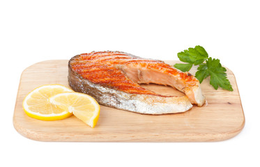 Grilled salmon with lemon and herbs on cutting board