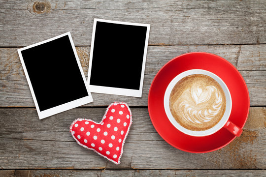 Two photo frames over wooden background with red coffee cup