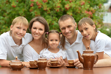 Family drinking tea outdoors