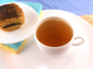 Cup of tea with poppy cookies on plate close-up