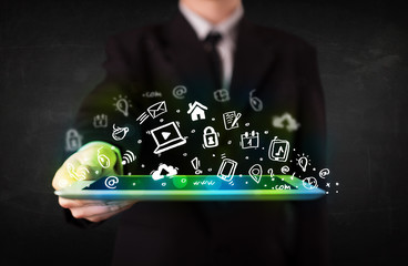 Person holding tablet with green media icons and symbols