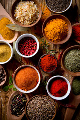 Assorted spices on wooden background - obrazy, fototapety, plakaty