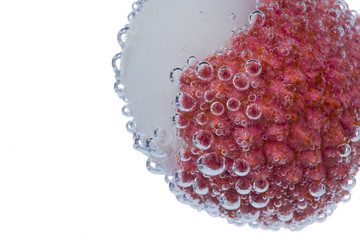Fresh lychee with water bubbles on white