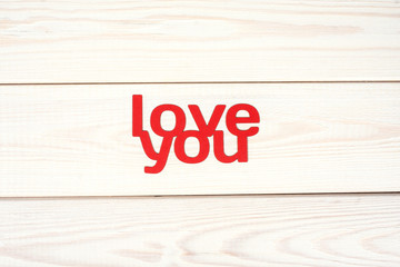 Words love you carved out of red paper