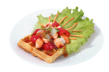 Brussels waffle on plate with lettuce leaf, paprika and fish.