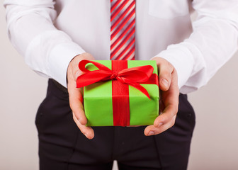 Businessman holds out the gift box ,isolated background