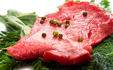a red meat with sage and rosemary isolated on white background