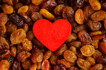 Diet healthy food. Raisin as background texture and red heart