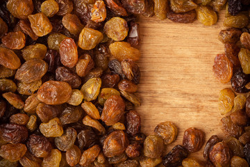 Diet healthy food. Border of raisin on wooden background
