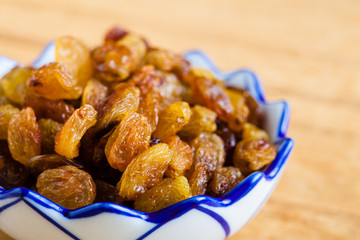 Diet healthy food. Raisin in bowl on wooden background