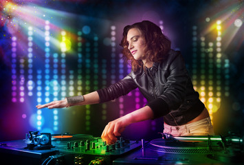 Fototapeta na wymiar Dj girl playing songs in a disco with light show