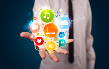 Young businessman presenting colorful technology icons and symbo