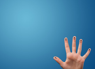 Happy smiley face fingers looking at empty blue background copy
