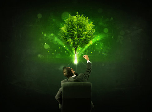 Businessman in chair sitting in front of a glowing tree