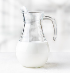 Jug of milk on the factory background. Half full pitcher