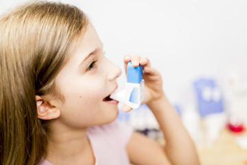 Obraz na płótnie Canvas Allergy - cute girl using inhaler