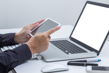 Man hand working on tablet with blank screen laptop computer