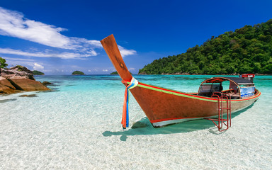 Long tail boat on white sand beach on tropical island - 60230338