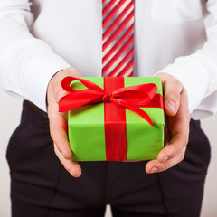Businessman holds out the gift box ,isolated background