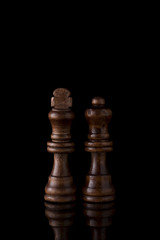 黒背景にキングとクイーンのチェス駒