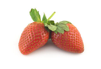Many ripe appetizing red strawberries with leaves as background