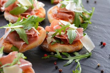Pizzahäppchen mit Schinken, Rucola und Parmesan