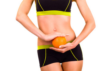 Slim figure of woman with orange in a hands