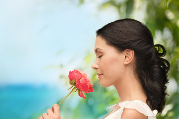 smiling woman smelling flower
