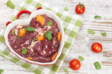 Chicken liver. Raw chicken liver in heart shaped bowl