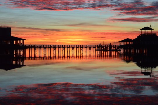 Sunrise at a marina pier with reflection