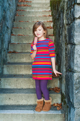 Outdoor portrait of a beautiful little girl with ice cream