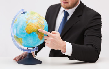 businessman pointing finger to earth globe