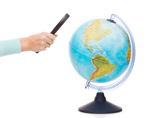 woman hand holding magnifying glass over globe