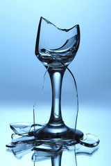 Broken wineglass on blue background