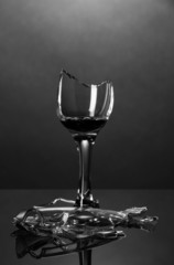 Broken wineglass on grey background