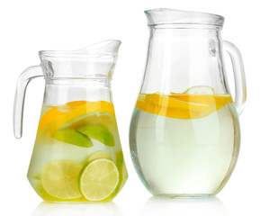 Cold water with lime, lemon and ice in pitchers isolated