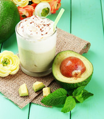 Fresh avocado smoothie on wooden background