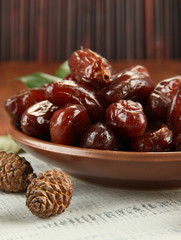 Dried dates on plate with bumps on table on bamboo background