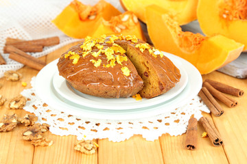 Delicious pumpkin pie on plate on wooden table close-up