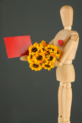 Wooden mannequin holding blank label and bouquet