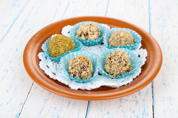 Set of chocolate candies, on plate, on wooden background