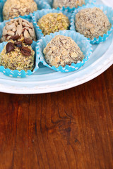 Set of chocolate candies, on plate, on wooden background