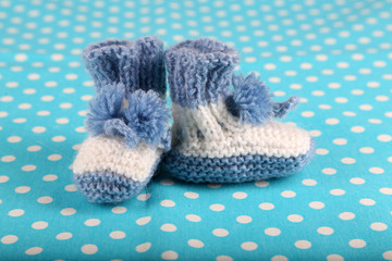 Fototapeta na wymiar Crocheted booties for baby, on color background