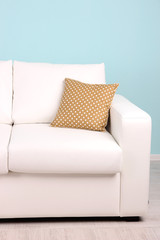 White sofa close-up in room on blue background