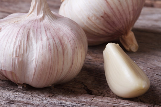 a clove of garlic and a whole wooden table closeup