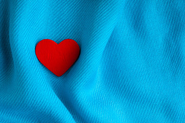 Valentine's day background. Red heart on blue folds cloth